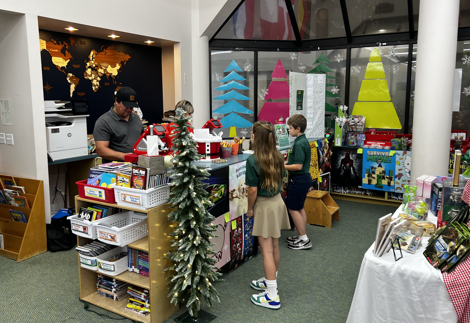 Two young Falcons check out with their new purchases at the lower school Book Fair.